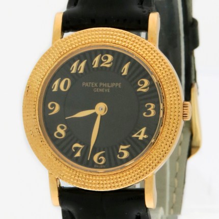 Gold-tone wristwatch with a textured bezel, black dial, and bold gold Arabic numerals on a black leather strap