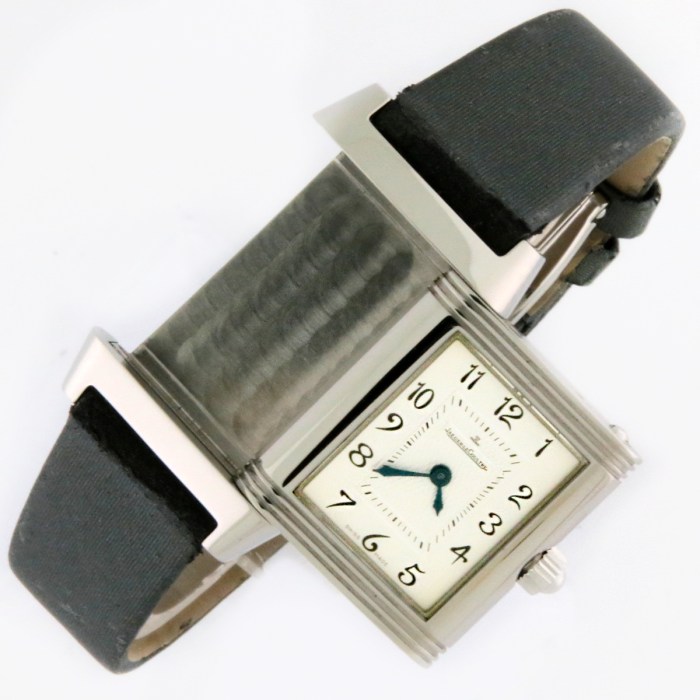 Rectangular-faced wristwatch with a white dial, black Arabic numerals, blue hands, and a black leather strap.
