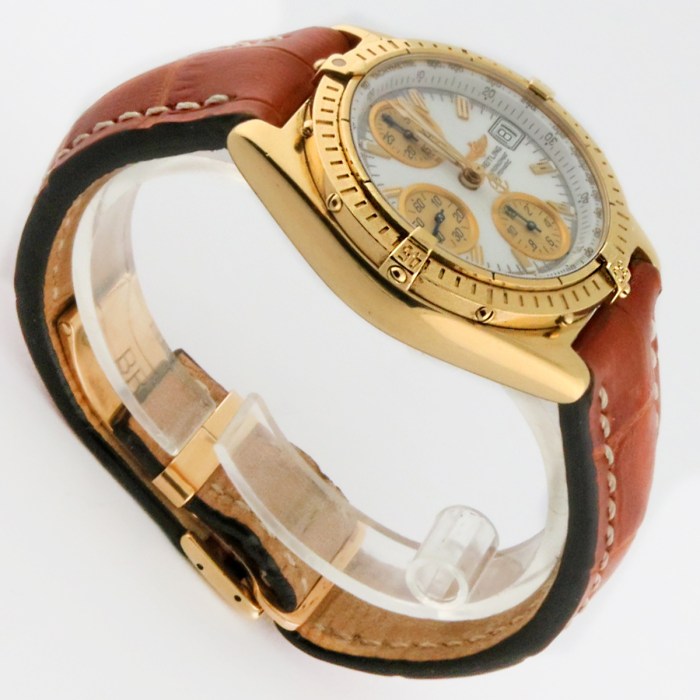 Gold-tone chronograph wristwatch with a brown leather strap, white dial and three subdials, shown at an angle on a white background.